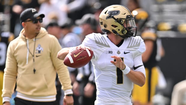 Purdue Boilermakers quarterback Hudson Card (1) warms up as head coach Ryan Walters looks on before the game against the Iowa Hawkeyes at Kinnick Stadium.